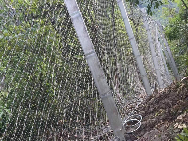 RX passive rockfall barrier with steel ring net along a mountain slope